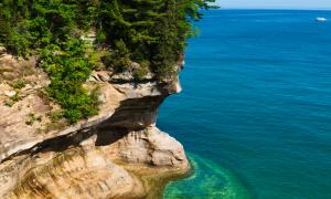 Lake Superior displays its vibrant colors below a sweeping cliffside formed by millennia of erosion. Pictured Rocks, Michigan. Great Lakes Water in Action. Chris Ingham.