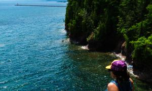 A hiker relaxes on the cliffs overlooking Lake Superior on Presque Isle. Marquette, Michigan. Recreation. Chris Ingham.