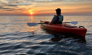 Watching the sun set on a calm evening from a kayak in Lake Ontario. </br>Lyndonville, New York </br>Recreation. Joe Pow.