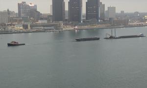 View of a tugboat and barge on the Detroit River. Looking at Detroit, MI from Windsor, CN. Windsor, Ontario. Great Lakes Water in Action. Dawn Schilling.
